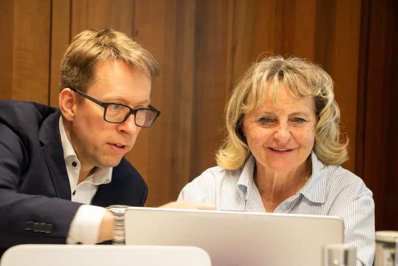 Daniel Schwenger und eine Frau schauen gemeinsam auf einen Laptop
